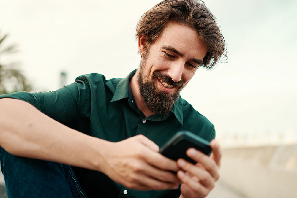 Mann am Telefon, der die Reisetechnologie zur Planung und Verwaltung von Geschäftsreisen nutzt