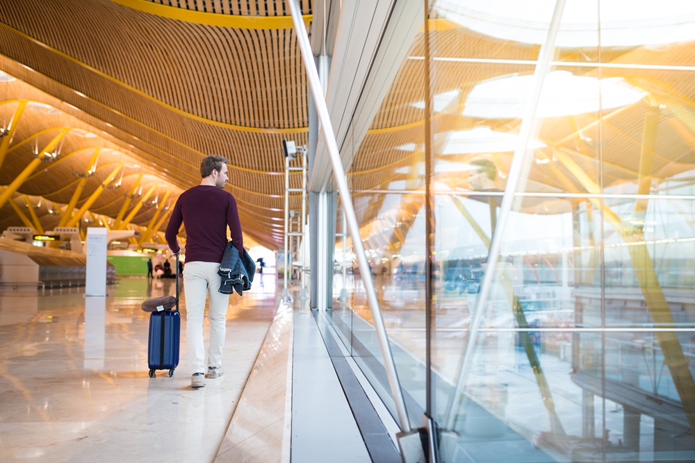 Vielflieger zu Fuß durch Flughafen-Terminal