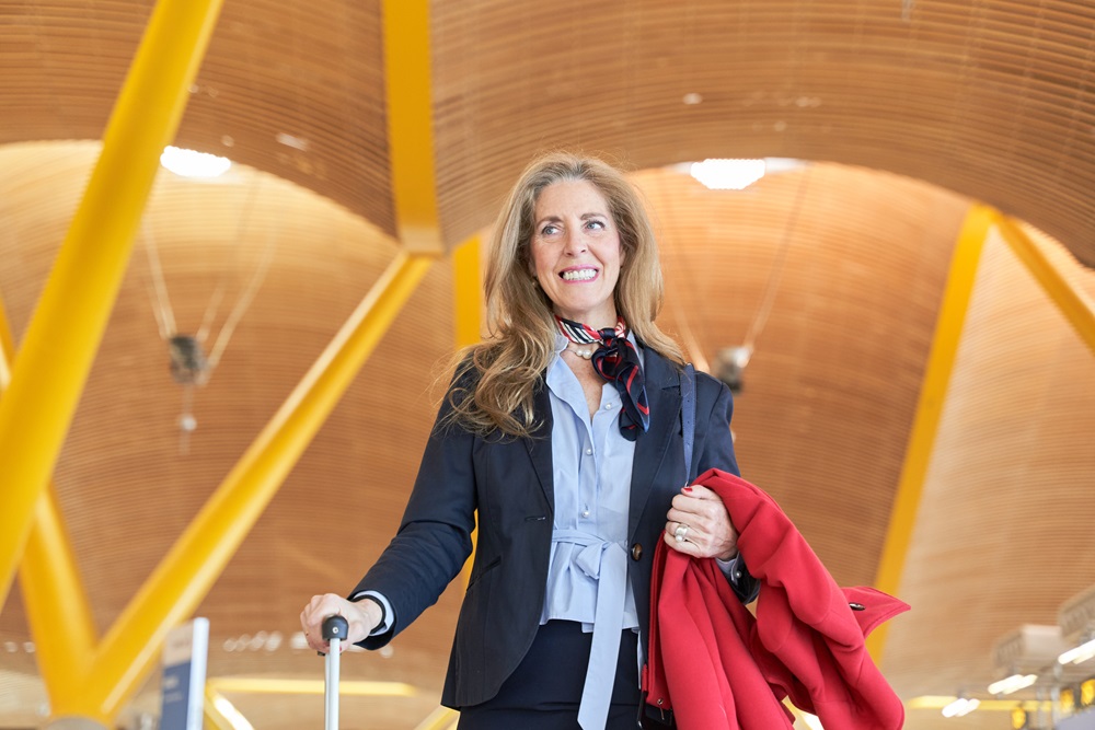 portrait of a middle aged business woman with travel luggage at the station Geschäftsreisender mit Koffer am Flughafen Madrid-Barajas.