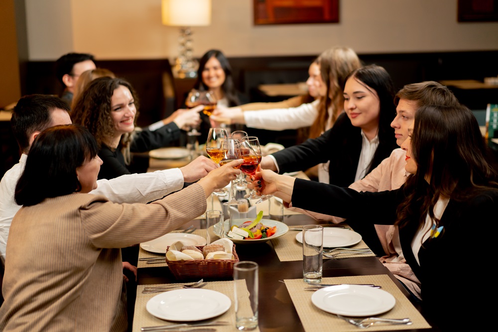 Arbeitskollegen stoßen beim Abendessen an