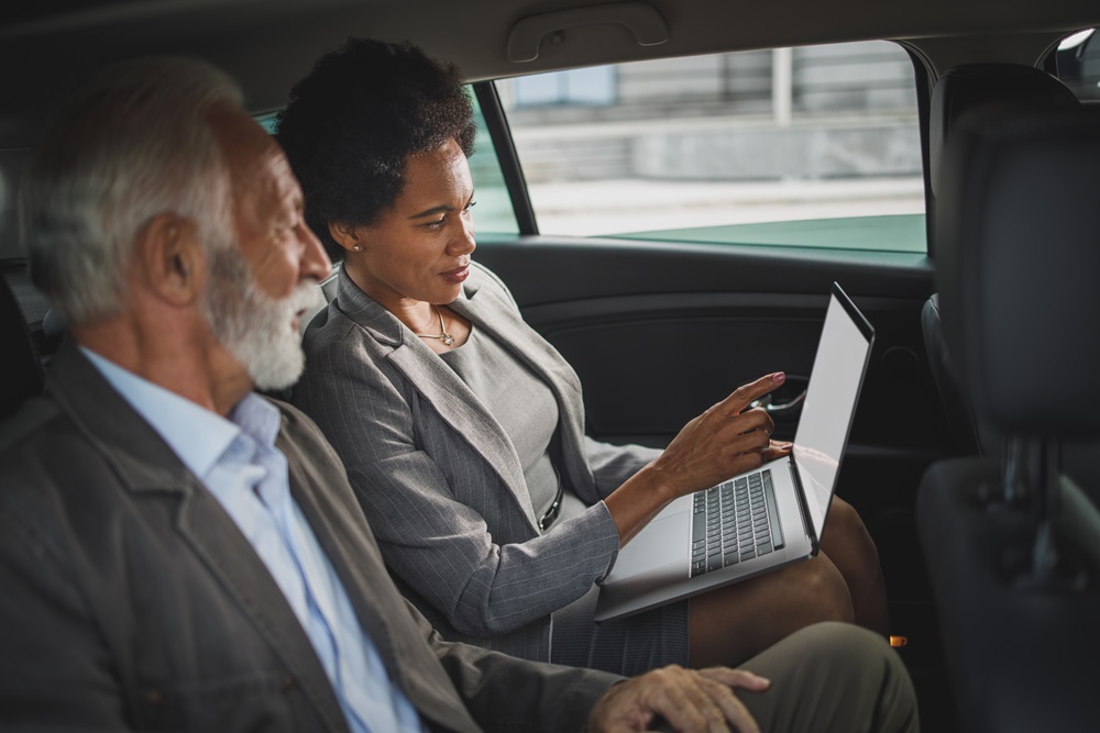 Zwei Kollegen arbeiten im Auto, um so viel wie möglich zu schaffen.