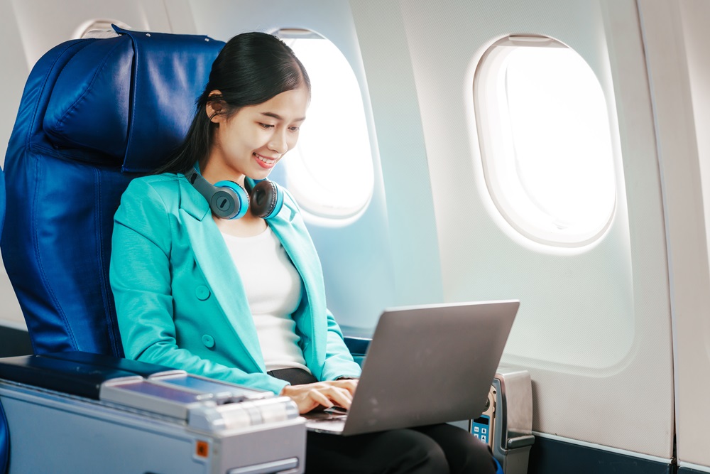 Business woman working from an early morning flight