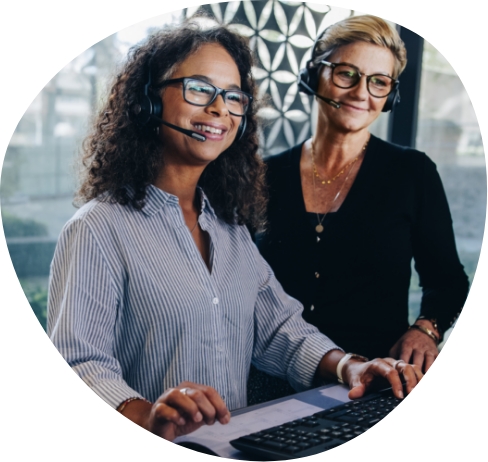 Two women travel experts with headphones and a computer keyboard
