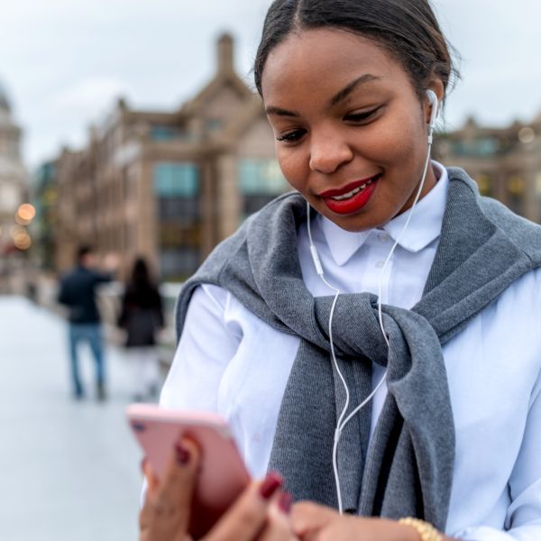 Woman looking at cell phone with headphones in