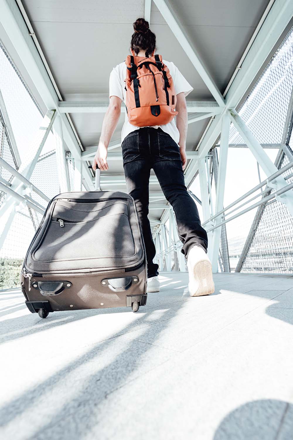 traveler in airport with backpack and suitcase