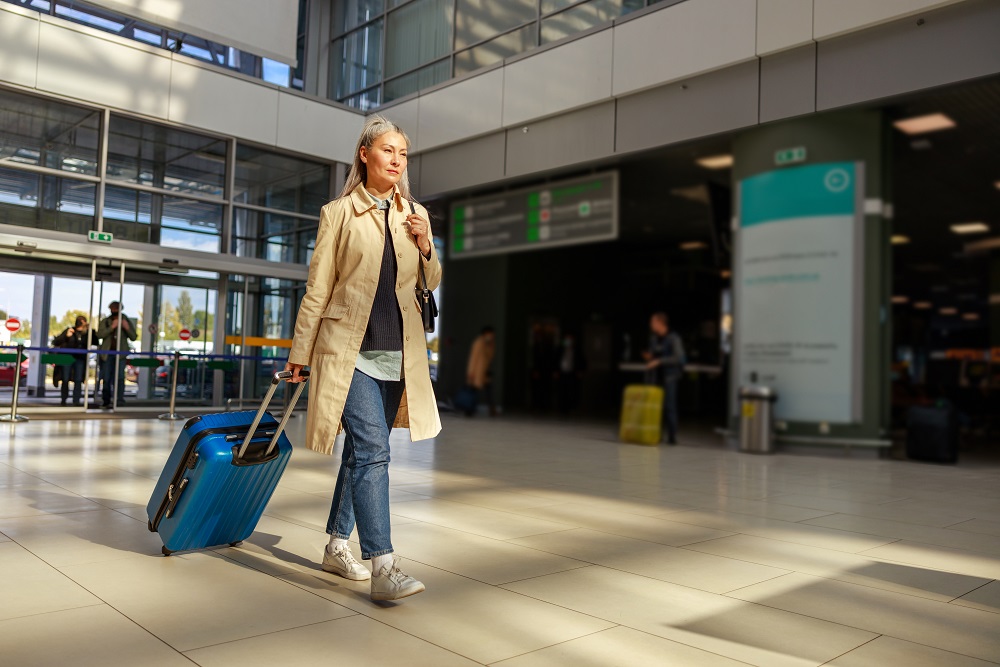 Woman in the airport with trolley traveling for business during thanksgiving travel