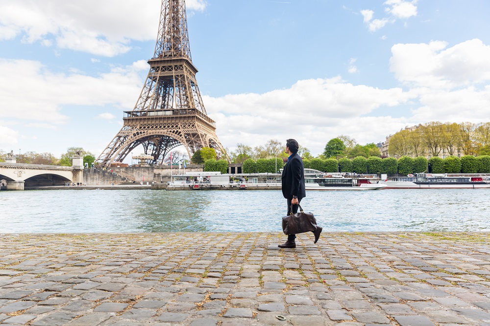 Businessman walking along the river in front of Eiffel Tower