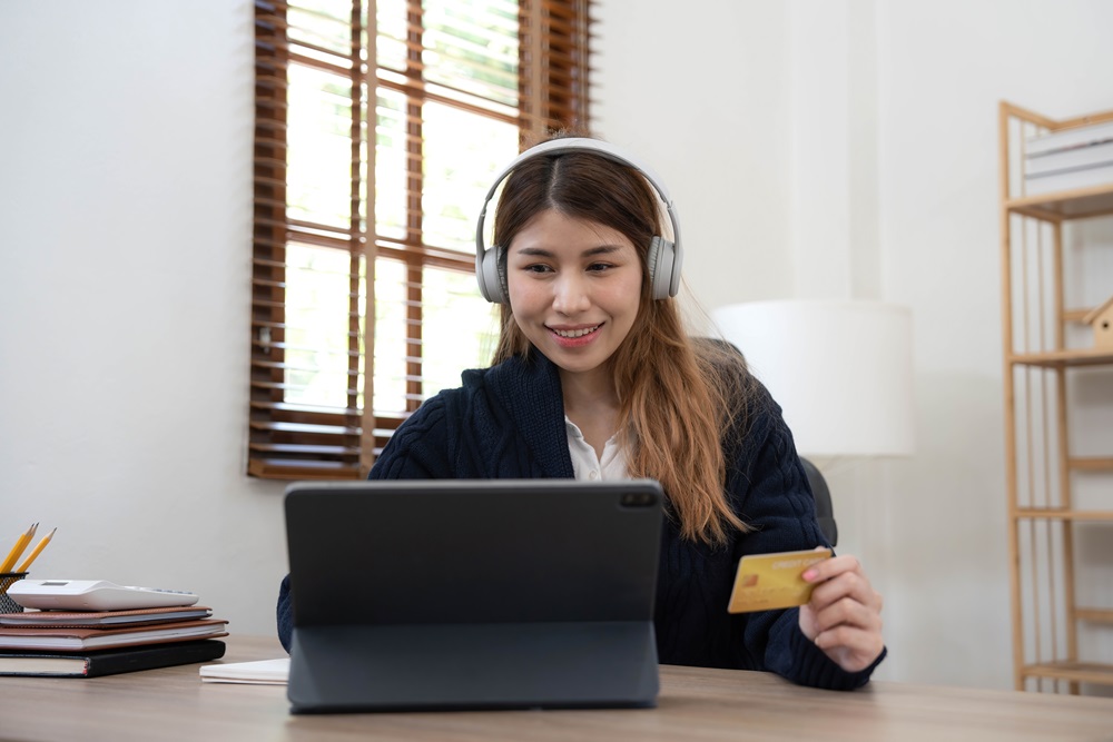 Girl with headphones making online virtual payment