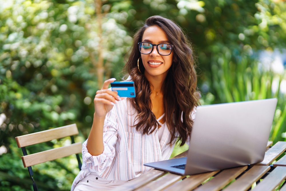 Business traveler booking travel with lodge card while working at a cafe with a laptop
