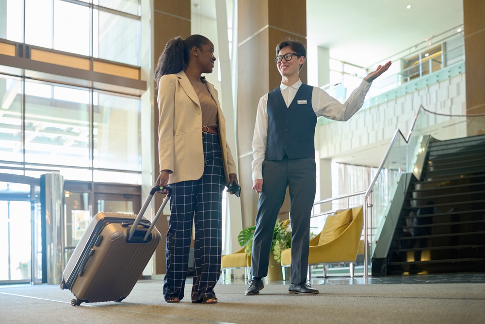 Business woman arriving at corporate accommodations with suitcase