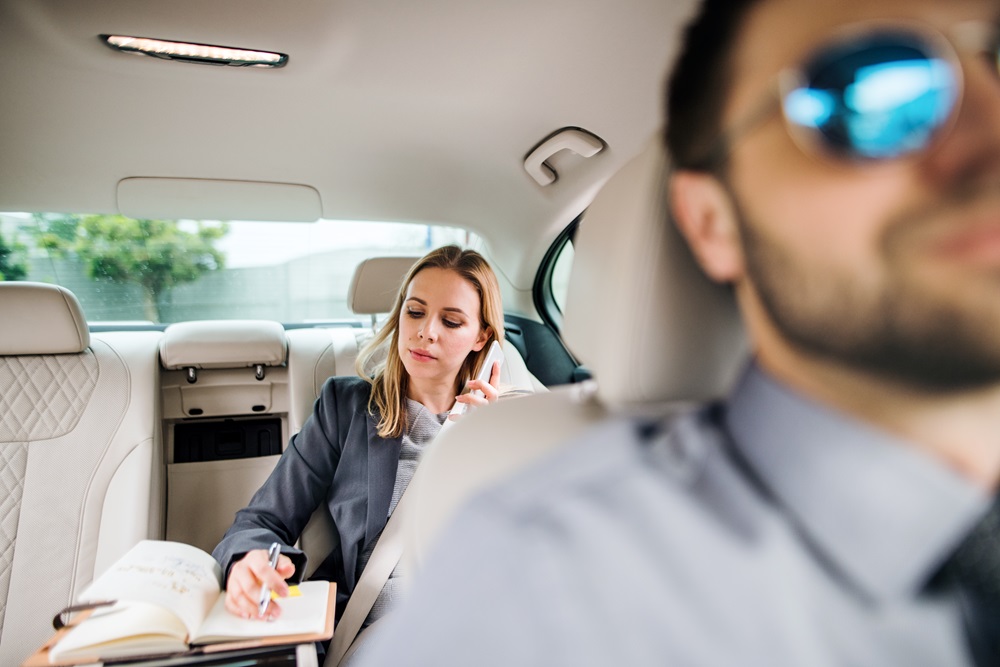Women working from the back of the car with chauffeur