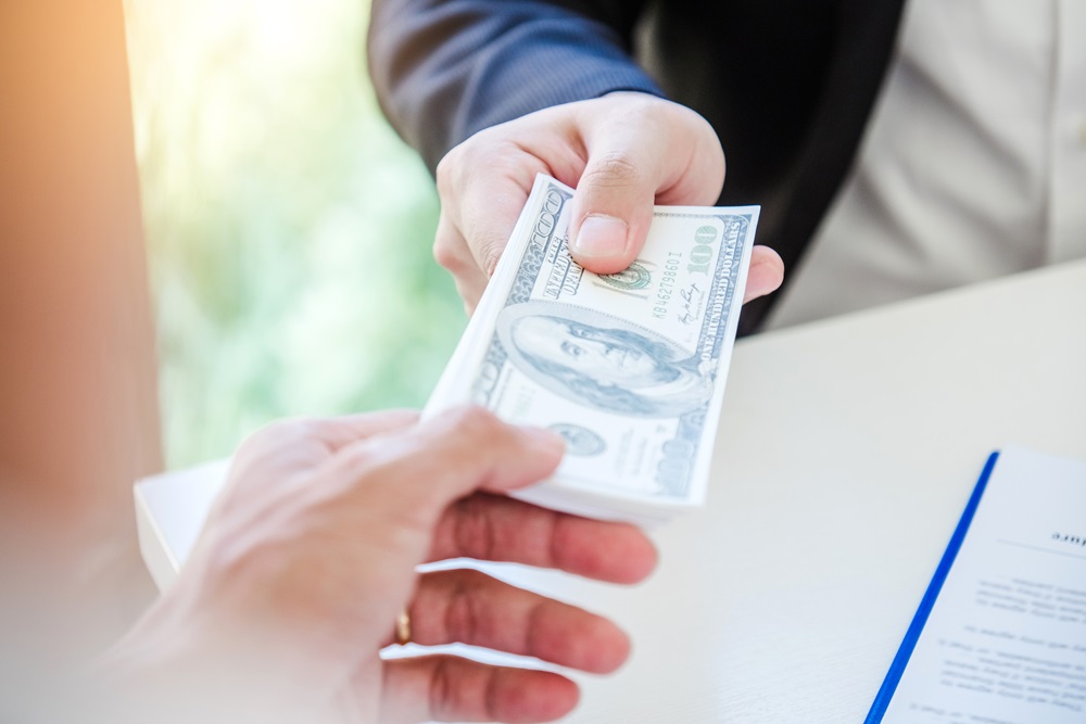 Man exchanging dollars for fraudulent business expenses