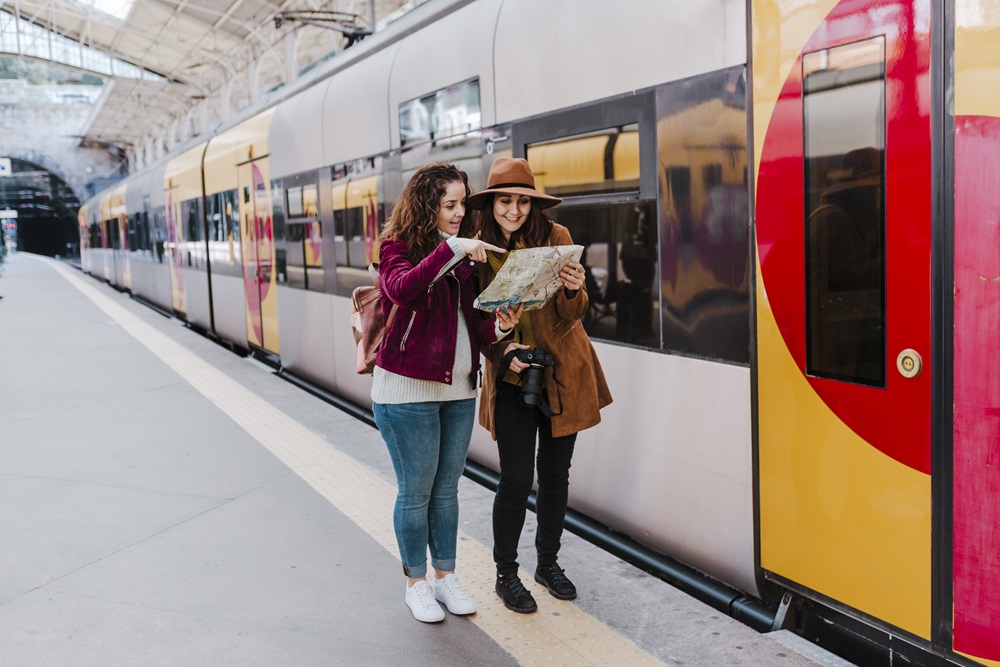 Two business travelers looking at map by train in Manchester