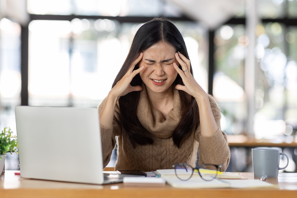 stressed employee Stressed woman at work working on her laptop