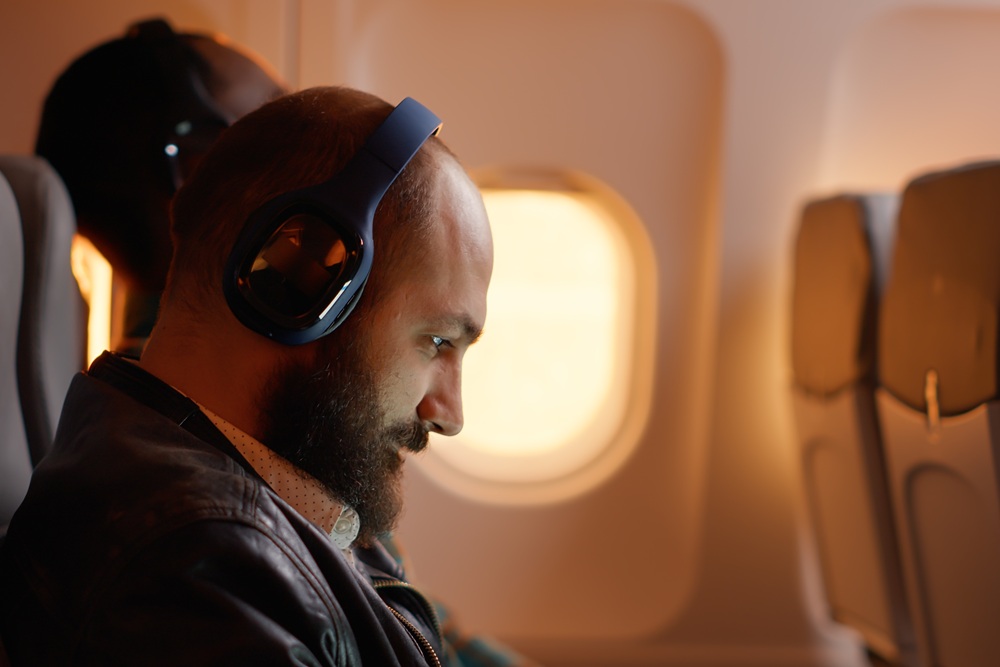 Business traveler listening to music on plane