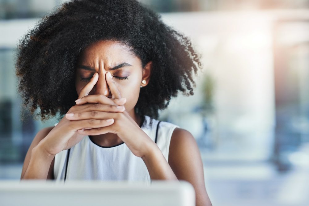 This headache is getting distracting. Stressed woman at desk